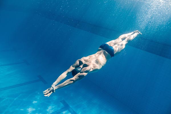 شناگر مرد در حال شنا در اعماق آب