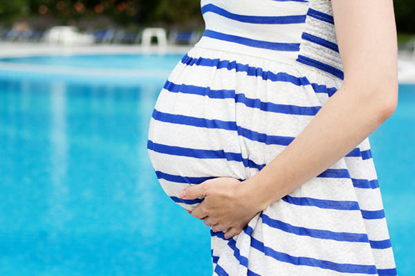 زن باردار در کنار استخر